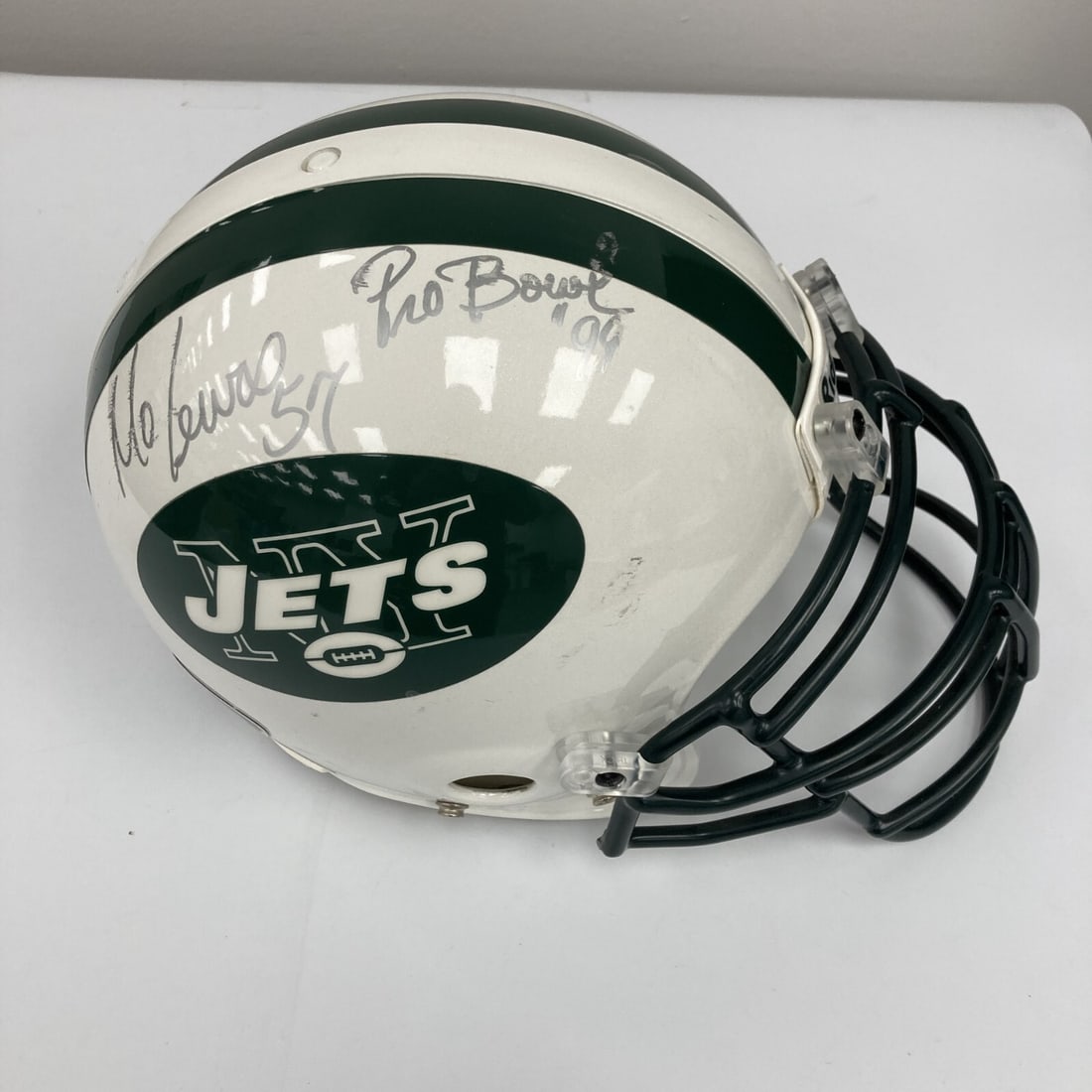 Mo Lewis 1999 Pro Bowl Signed Game Used Jets Helmet with JSA COA: Mo Lewis 1999 Pro Bowl Signed Game Used Jets Helmet with JSA COA This authentic 1999 Pro Bowl helmet, signed by Mo Lewis, is a must-have for any New York Jets fan. The helmet is a game-used piece, sho