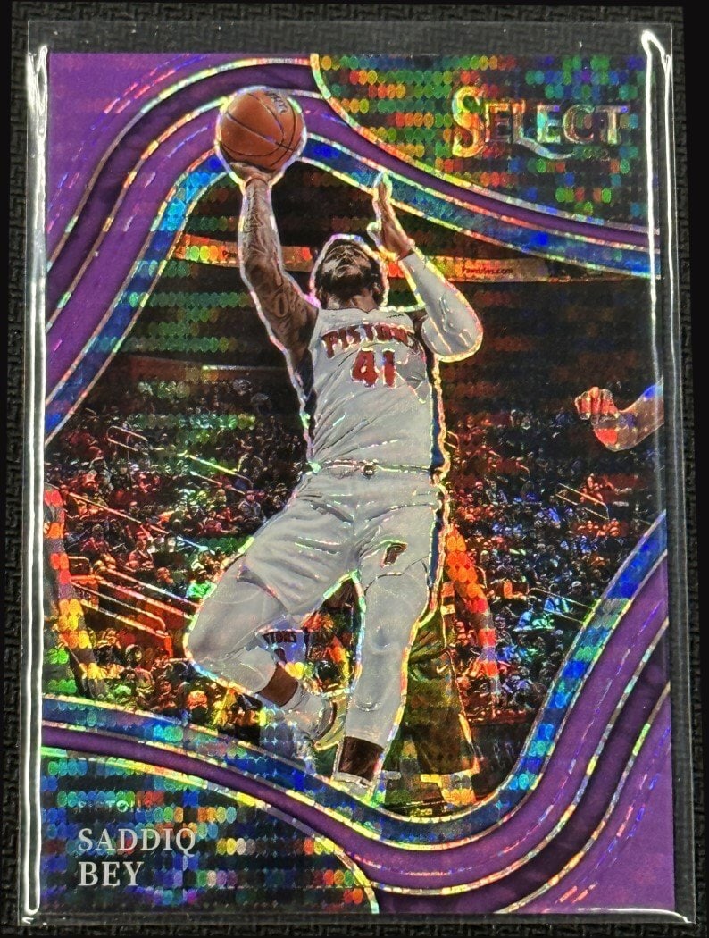 Saddiq Bey Neon Purple Pulsar FOTL Panini Select Basketball Card 2021 #213: Saddiq Bey Neon Purple Pulsar FOTL Panini Select Basketball Card 2021 #213 This is a Saddiq Bey 2021-22 Panini Select Neon Purple Pulsar FOTL basketball card, featuring the Detroit Pistons player. The