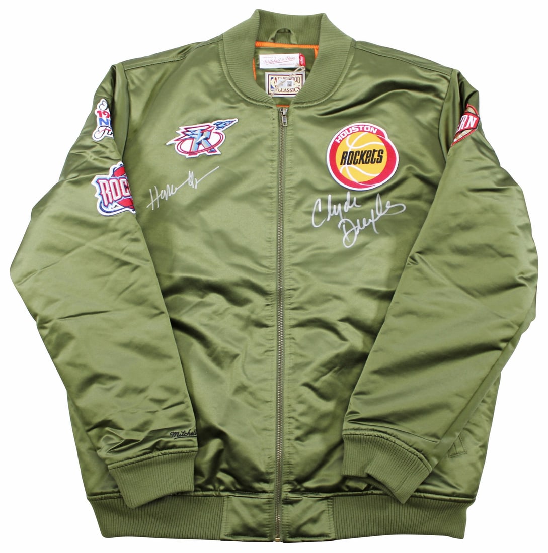 Mitchell & Ness Green Bomber Signed by Hakeem Olajuwon Clyde Drexler BAS Authenticated: Mitchell & Ness Green Bomber Signed by Hakeem Olajuwon Clyde Drexler BAS Authenticated This green satin Mitchell & Ness bomber jacket features the authentic hand signatures of Hakeem Olajuwon and Clyd