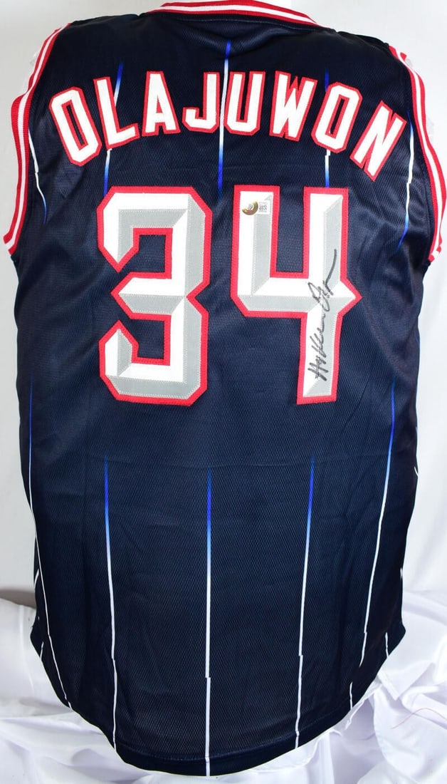 Hakeem Olajuwon Signed Blue Rockets Jersey Beckett Authenticated: Hakeem Olajuwon Signed Blue Rockets Jersey Beckett Authenticated This authentic blue pro-style jersey is signed by basketball legend Hakeem Olajuwon, a distinguished player for the Houston Rockets. Th