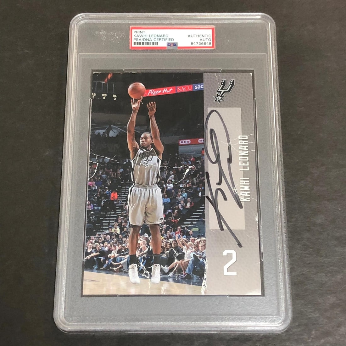 PSA DNA signed Kawhi Leonard Spurs photo 5 3 4 x 8: PSA DNA signed Kawhi Leonard Spurs photo 5 3 4 x 8 This is an original professionally printed photograph measuring 5 3/4 x 8 inches, autographed by Kawhi Leonard of the San Antonio Spurs. The signatur
