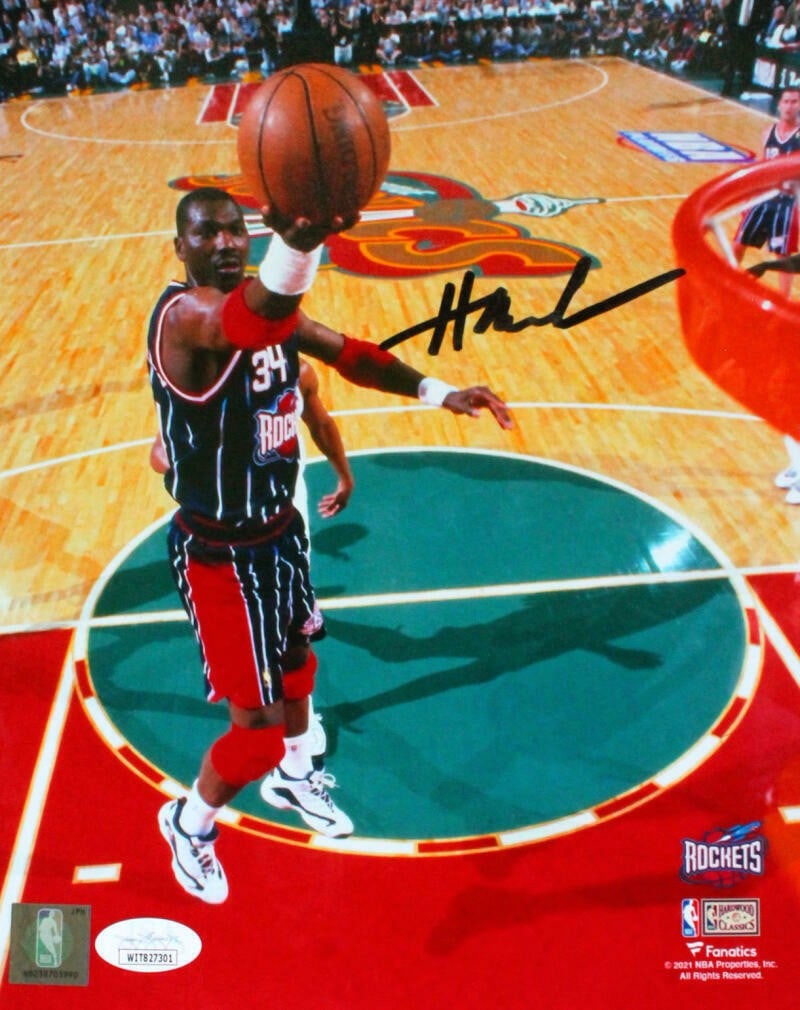 Hakeem Olajuwon signed Houston Rockets 8x10 layup photo JSA: Hakeem Olajuwon signed Houston Rockets 8x10 layup photo JSA This is an original 8x10 photograph featuring Hakeem Olajuwon of the Houston Rockets. The photo captures Olajuwon performing a lay up and is