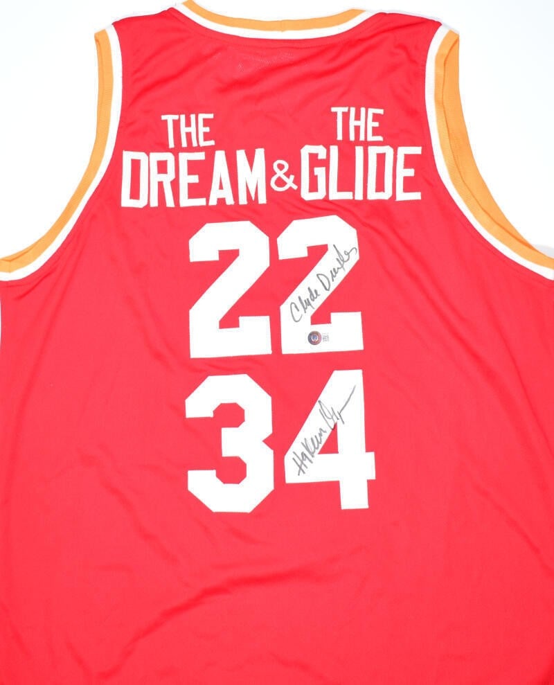 Houston Rockets red pro style jersey signed by Olajuwon and Drexler Beckett holo: Houston Rockets red pro style jersey signed by Olajuwon and Drexler Beckett holo This red pro style jersey is autographed by both Hakeem Olajuwon and Clyde Drexler. Representing the Houston Rockets,