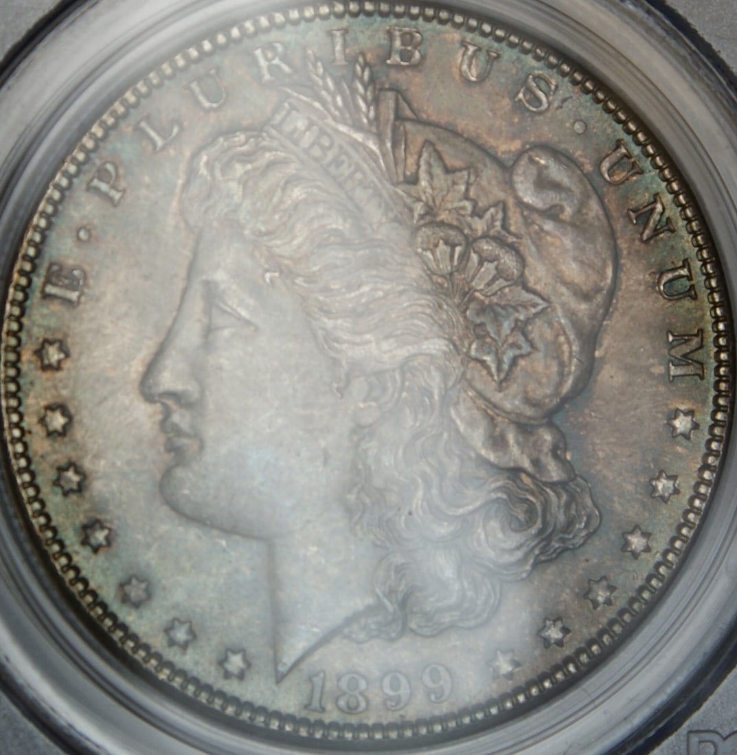 PCGS MS-64 1899-O Morgan Dollar with Attractive Toning: PCGS MS-64 1899-O Morgan Dollar with Attractive Toning This 1899-O Morgan Silver Dollar is graded MS-64 by PCGS and features beautiful toning. Minted in New Orleans, this uncirculated coin is composed