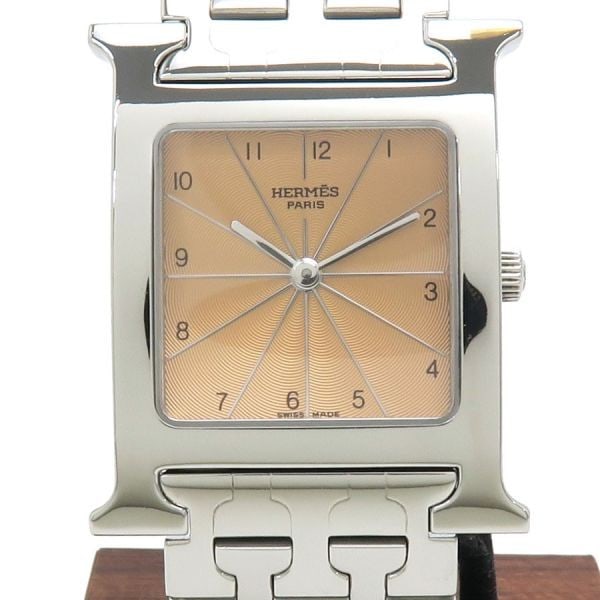 Hermes HH1.510 stainless steel quartz wristwatch: Hermes HH1.510 stainless steel quartz wristwatch This pre-owned HERMES H Watch HH1.510 is a classic men's wristwatch featuring a distinctive pink dial and a silver stainless steel case. The bold "H" m