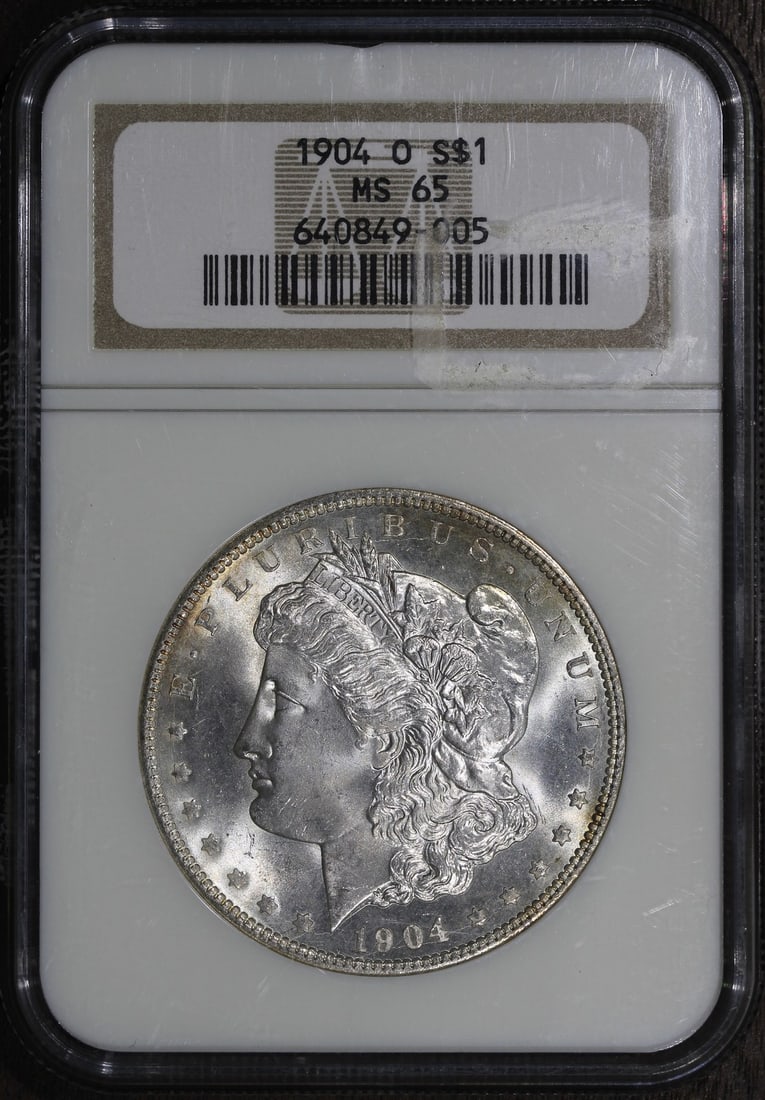 NGC MS65 1904-O Morgan Dollar Silver $1 US Coin: NGC MS65 1904-O Morgan Dollar Silver $1 US Coin This is a 1904-O Morgan Silver Dollar $1 graded MS65 by NGC. The coin is uncirculated and pre-owned, with a silver composition and a fineness of 0.9. It