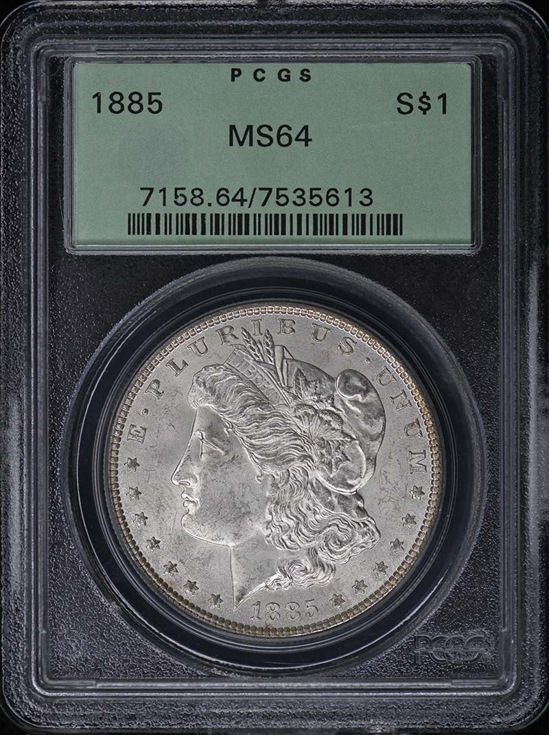 PCGS MS64 1885 Morgan Silver Dollar OGH: PCGS MS64 1885 Morgan Silver Dollar OGH This is an 1885 Morgan Dollar graded MS64 by PCGS and housed in an Old Green Holder (OGH). The coin is uncirculated and originates from the Philadelphia Mint. I