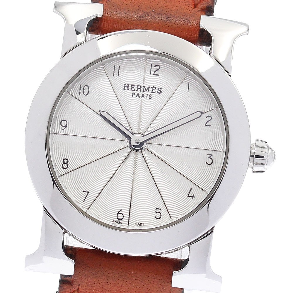 Hermes H-Watch Ronde Quartz Ladies Wristwatch HR1.210: Hermes H-Watch Ronde Quartz Ladies Wristwatch HR1.210 This HERMES H-Watch Ronde is a pre-owned women's wristwatch featuring a stainless steel case and a silver dial. It is powered by a quartz movement