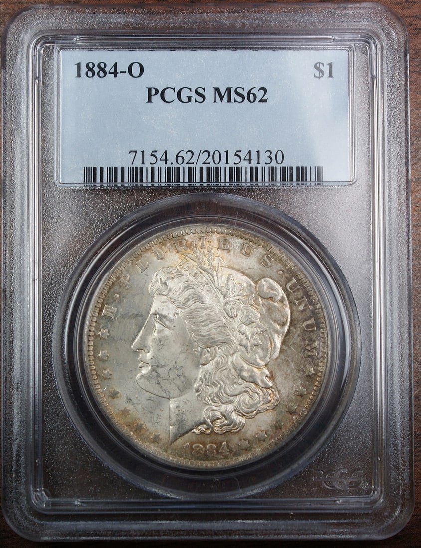 PCGS MS62 1884-O Morgan Silver Dollar Toned: PCGS MS62 1884-O Morgan Silver Dollar Toned This 1884-O Morgan Silver Dollar features interesting toning on the obverse and is graded MS-62 by PCGS. Struck in New Orleans, this uncirculated coin is co