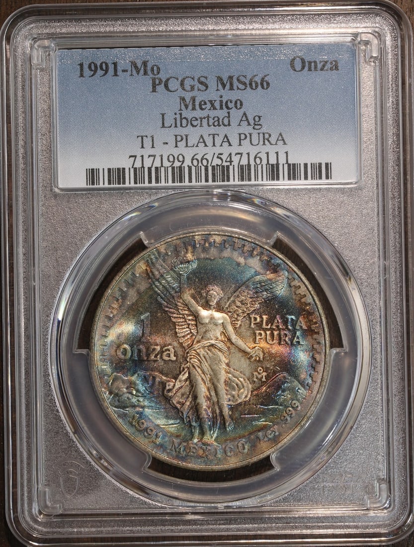 PCGS MS66 1991-Mo Mexico Silver Libertad Onza 1 oz Coin: PCGS MS66 1991-Mo Mexico Silver Libertad Onza 1 oz Coin This 1991 Mexico Silver Libertad Onza is graded MS66 by PCGS and shows beautiful toning. It is a pre-owned coin struck in 0.999 fine silver with
