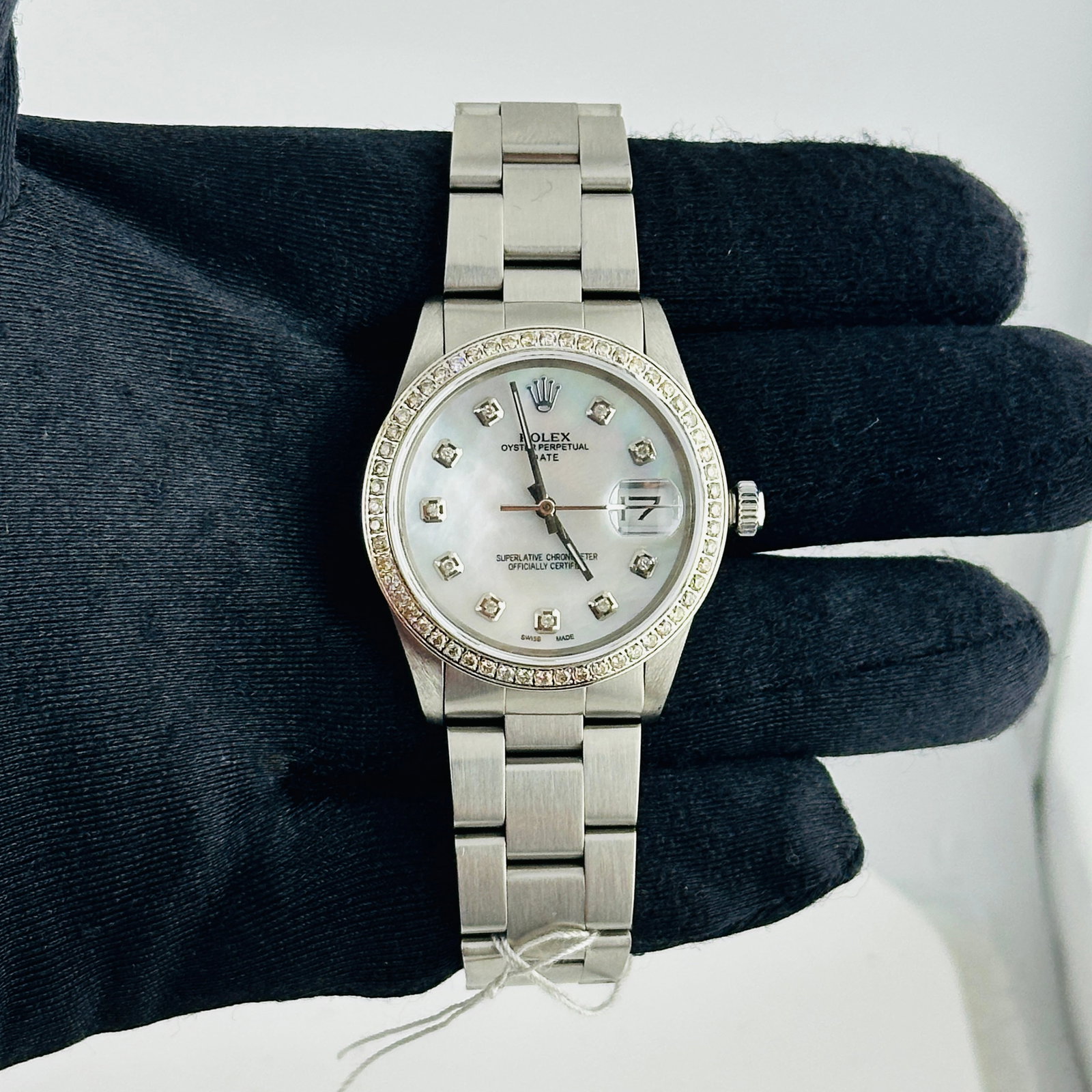 Rolex Oyster Perpetual Date 15000 Aftermarket White MOP Diamond Dial Oyster Bracelet: Rolex Oyster Perpetual Date 15000 Aftermarket White MOP Diamond Dial Oyster Bracelet This Rolex Oyster Perpetual Date features a white mother-of-pearl diamond dial and a pave diamond bezel, paired wit