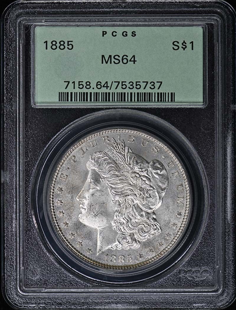 1885 Morgan Dollar PCGS MS64 OGH: 1885 Morgan Dollar PCGS MS64 OGH This 1885 Morgan Dollar is graded MS64 by PCGS and is housed in an Old Green Holder (OGH). The coin is uncirculated and originates from the Philadelphia Mint. It repre