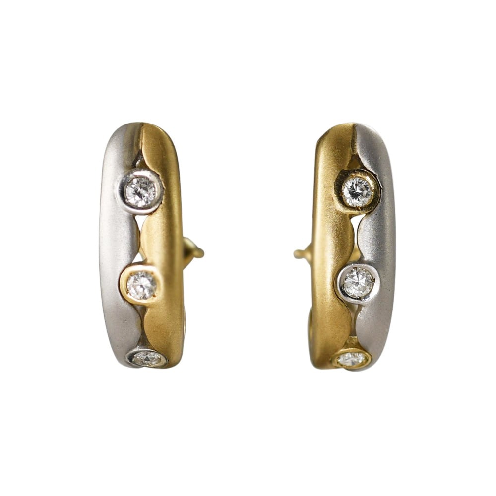 14k Two Tone Diamond J Hoop Earrings Omega Back 6 Stones: 14k Two Tone Diamond J Hoop Earrings Omega Back 6 Stones These elegant hoop earrings are crafted in 14k two-tone gold and feature a modern J-shaped design. Each earring is set with three bezel-set dia