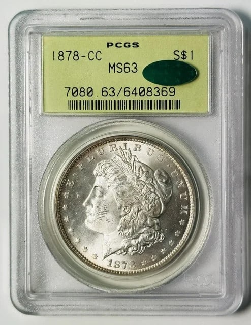 1878 Carson City Morgan dollar PCGS MS63 CAC OGH: 1878 Carson City Morgan dollar PCGS MS63 CAC OGH This is an 1878 Carson City Morgan Silver Dollar graded MS-63 by PCGS and verified by CAC. The coin is housed in an old green holder (OGH), indicating 