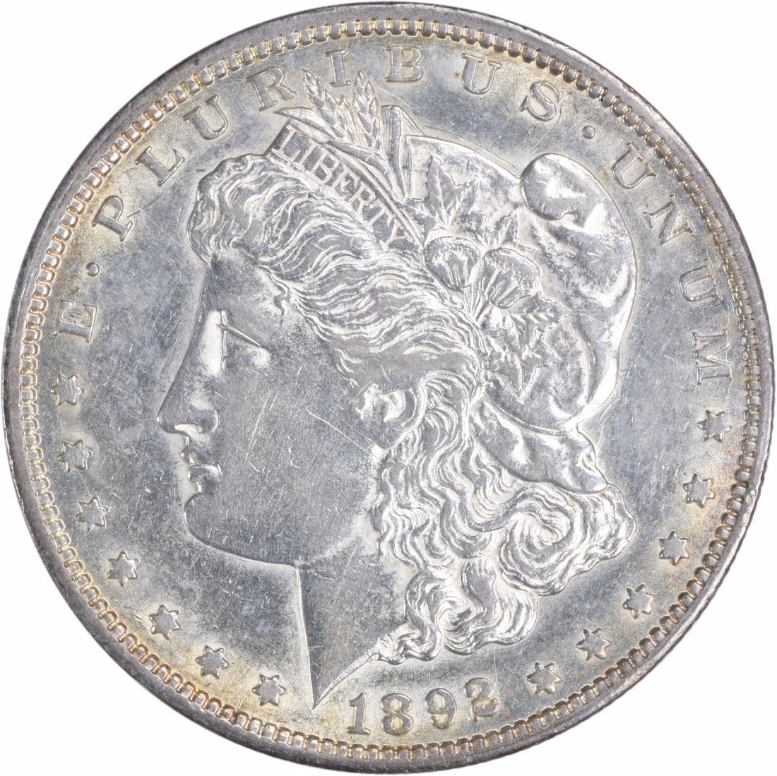 1892-CC Morgan Silver Dollar AU Uncertified 90% Silver Coin: 1892-CC Morgan Silver Dollar AU Uncertified 90% Silver Coin This 1892-CC Morgan Silver Dollar is a remarkable piece of numismatic history, featuring a design by George T. Morgan. The coin, minted in C