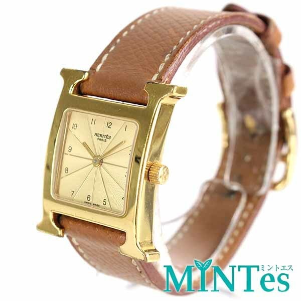 Hermes HH1.201 Gold Brown Quartz Wristwatch: Hermes HH1.201 Gold Brown Quartz Wristwatch This Hermes H Watch for women features a gold and brown design with a stainless steel case and leather strap. The watch is powered by a quartz movement and 