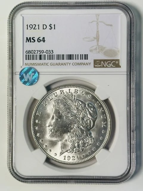 NGC MS 64 1921 D Morgan Silver Dollar Sight White: NGC MS 64 1921 D Morgan Silver Dollar Sight White 1921 D Morgan Silver Dollar certified by NGC and graded MS 64. This pre-owned coin is composed of silver and has a Sight White appearance. It is a 192