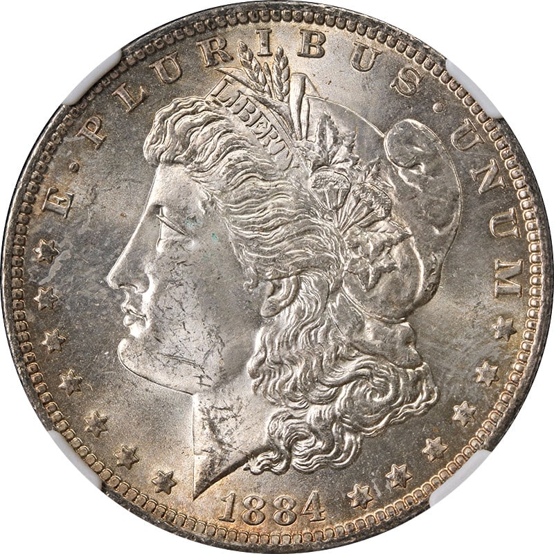 NGC MS63 Graded 1884-O Silver Morgan Dollar With Toned Surfaces: NGC MS63 Graded 1884-O Silver Morgan Dollar With Toned Surfaces This 1884-O Morgan Silver Dollar is graded MS63 by NGC and features attractive toning. The coin is uncirculated and composed of 90% silv