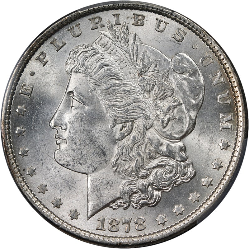 PCGS MS63 1878-P Morgan Silver Dollar 7TF Rev 79 Blast White: PCGS MS63 1878-P Morgan Silver Dollar 7TF Rev 79 Blast White This 1878-P 7 Tail Feathers Reverse of 1879 Morgan Silver Dollar is graded MS63 by PCGS. Struck in silver with a fineness of 0.9, this unci