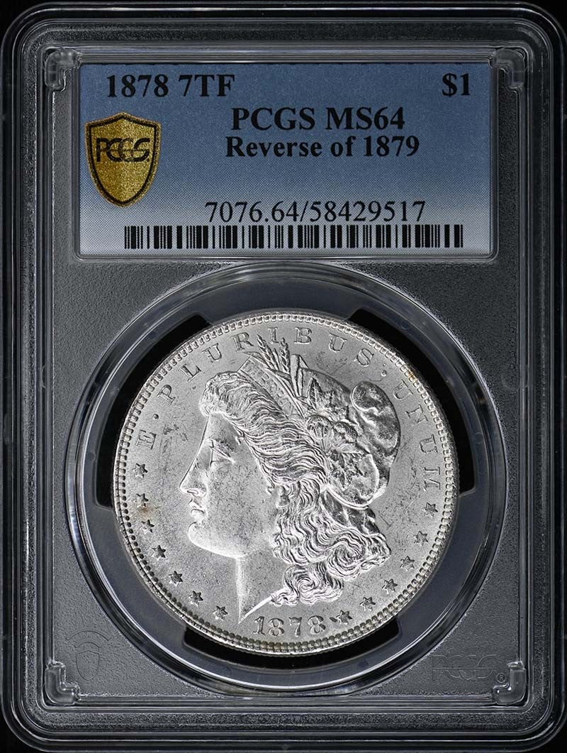 Morgan Dollar 1878 7 Tail Feathers Reverse 1879 PCGS MS64: Morgan Dollar 1878 7 Tail Feathers Reverse 1879 PCGS MS64 This is an 1878 7 Tail Feathers Morgan Dollar featuring the Reverse of 1879, certified by PCGS with a grade of MS64. The coin is uncirculated 