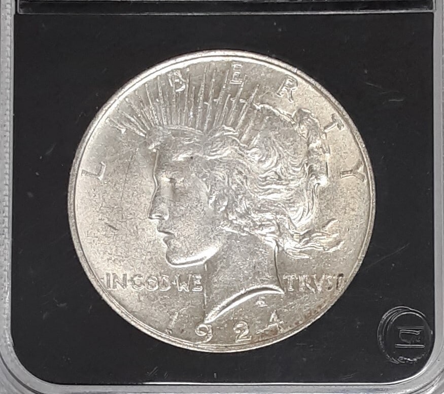 1924 Philadelphia Peace Dollar Almost Uncirculated Silver Coin in Display Holder: 1924 Philadelphia Peace Dollar Almost Uncirculated Silver Coin in Display Holder This is a 1924 Peace Silver Dollar coin from the Philadelphia Mint. The coin is composed of 90% silver and is in almost