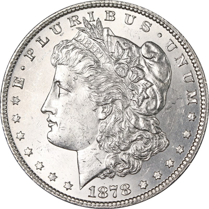 1878 P Morgan Silver Dollar 7TF: 1878 P Morgan Silver Dollar 7TF This is a 1878-P 7 Tail Feathers Morgan Silver Dollar from the United States. The coin is composed of silver with a fineness of 0.9 and has been circulated. It is an un