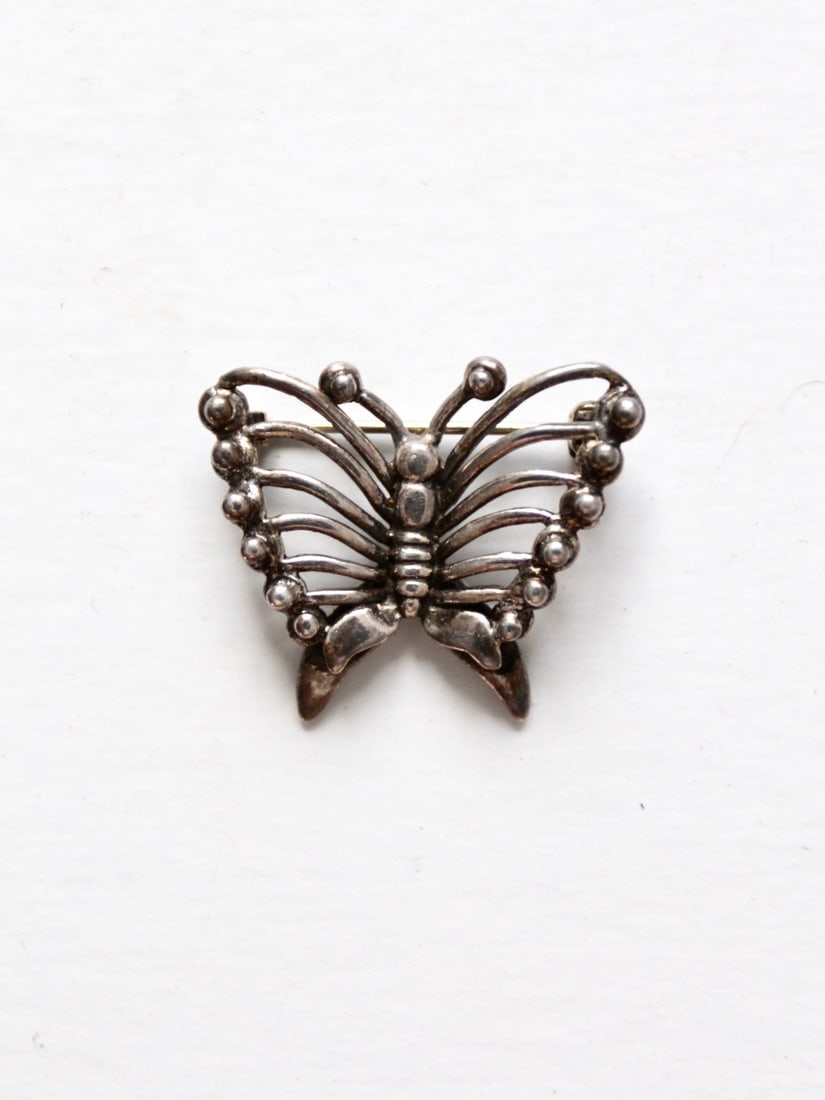 Elegant Vintage Silver Tone Butterfly Brooch with Dotted Design: Elegant Vintage Silver Tone Butterfly Brooch with Dotted Design This vintage butterfly brooch showcases an elegant silver tone finish adorned with a charming dotted design. It features a safety clasp 