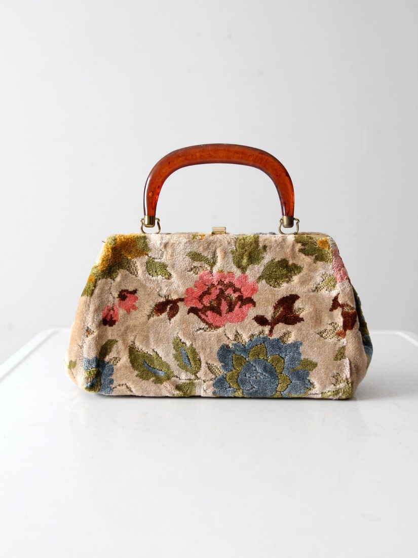 Authentic 1960s Floral Carpet Bag with Brown Handles: Authentic 1960s Floral Carpet Bag with Brown Handles Discover the charm of this authentic 1960s vintage carpet bag, adorned with a vibrant floral design. It features a sturdy top frame and brown top h