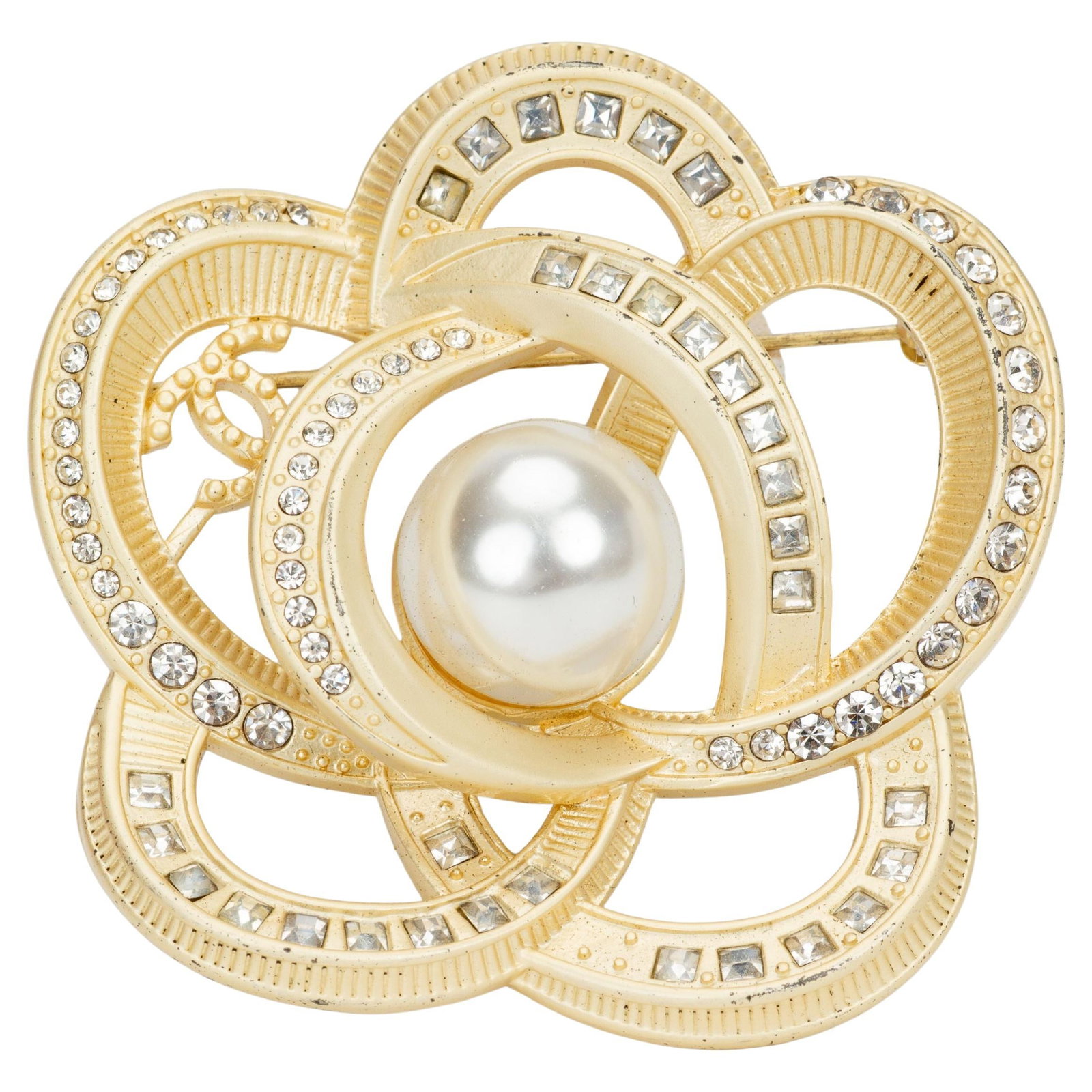 Chanel Camelia Pin Light Gold Plated Metal Pearl Center: Chanel Camelia Pin Light Gold Plated Metal Pearl Center This Chanel Camelia pin from the Autumn 2020 collection features light gold plated metal adorned with rhinestones and a pearl center. Crafted in