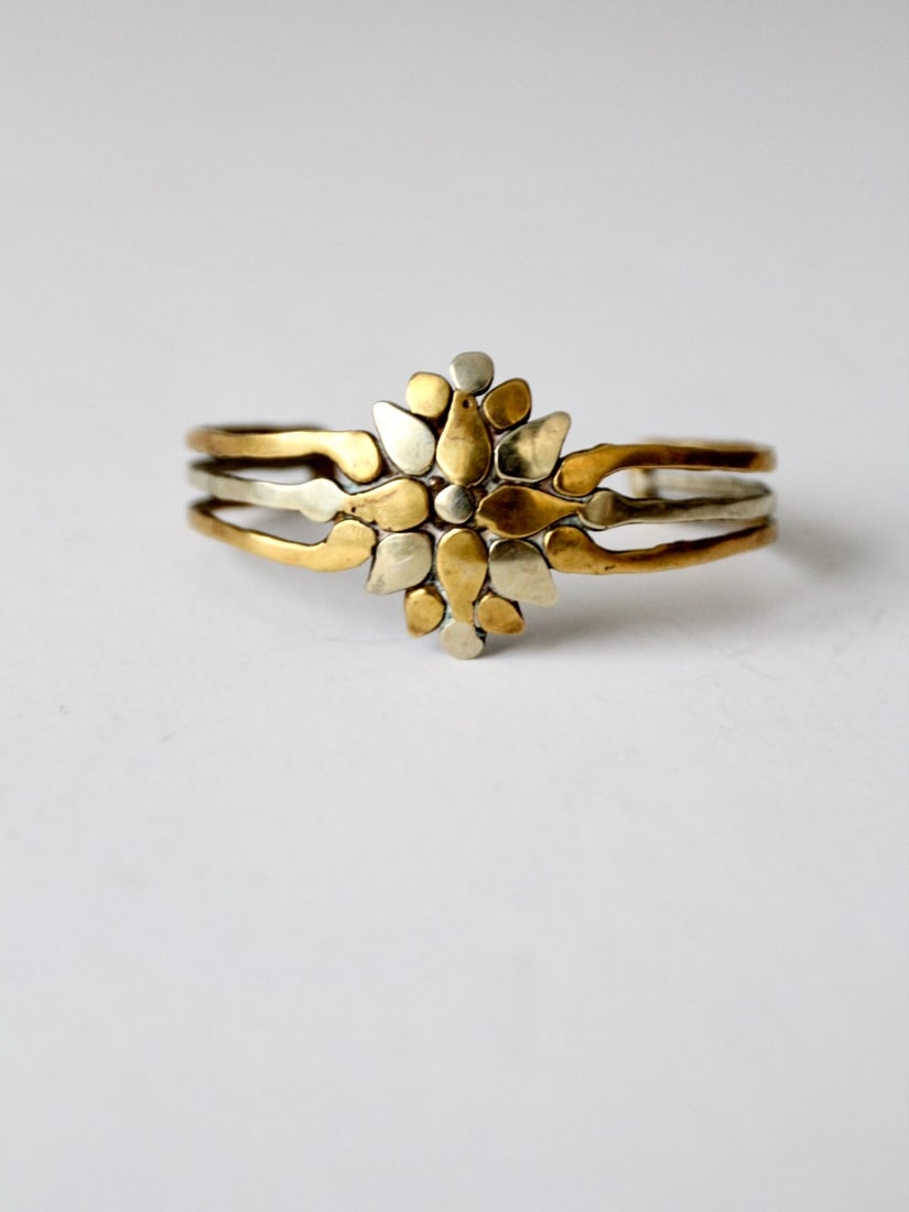 1970s Vintage Brutalist Brass Cuff Bracelet with Two-Tone Design: 1970s Vintage Brutalist Brass Cuff Bracelet with Two-Tone Design This striking Vintage Brutalist Brass Cuff from the 1970s showcases a unique design that combines geometric and floral elements, enhanc
