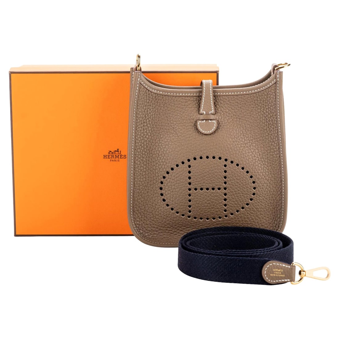 Hermes Mini Evelyne Etoupe Blue Leather Bag with Gold Tone Hardware: Hermes Mini Evelyne Etoupe Blue Leather Bag with Gold Tone Hardware Introducing the exquisite Hermes Mini Evelyne bag, crafted from luxurious Etoupe Taurillon Clemence leather. This elegant bag featur