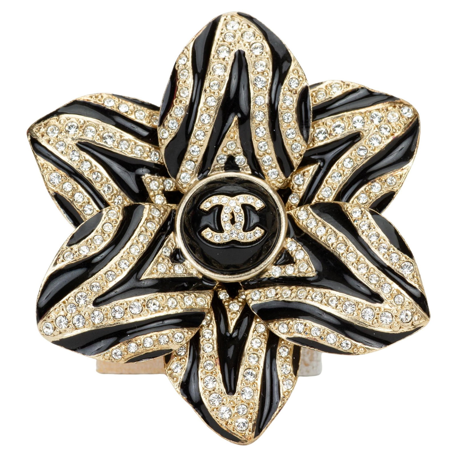 Chanel Cruise 23 Rhinestone CC Flower Pin: Chanel Cruise 23 Rhinestone CC Flower Pin This Chanel Cruise 23 flower pin features a striking black and gold-plated metal design, embellished with rhinestones and a central CC logo. Crafted in France