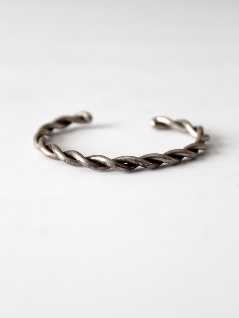 Vintage Twisted Silver Tone Cuff Bracelet 6.25 inch: Vintage Twisted Silver Tone Cuff Bracelet 6.25 inch This vintage cuff bracelet showcases a stylish twisted design crafted from silver tone metal, creating a slender and elegant piece. The bracelet is 