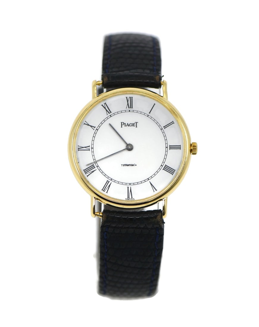 Piaget Ref 8065 Tiffany Co 18K Yellow Gold Classic Wristwatch: Piaget Ref 8065 Tiffany Co 18K Yellow Gold Classic Wristwatch Piaget Classic Tiffany & Co wristwatch in 18K yellow gold with a white dial and leather band. This men's analog watch features a quartz mo
