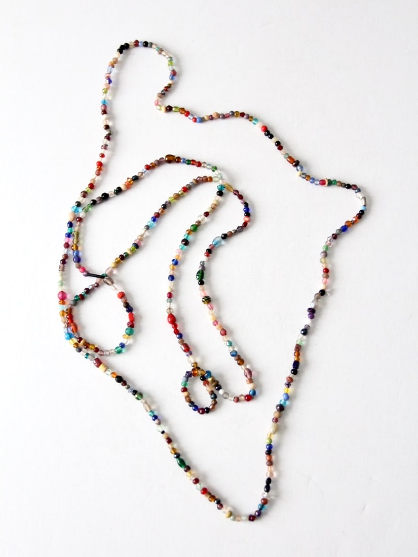 Vibrant Vintage Beaded Necklaces Set of 2 Long Strands: Vibrant Vintage Beaded Necklaces Set of 2 Long Strands Elevate your accessory game with this pair of vintage beaded strand necklaces. These long, slender necklaces feature a stunning array of colors a