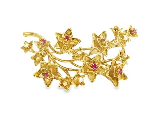 Tiffany & Co. 18k Yellow Gold Floral Brooch with Ruby and Diamond: Tiffany & Co. 18k Yellow Gold Floral Brooch with Ruby and Diamond An elegant floral spring-inspired brooch crafted in 18k yellow gold and accented with rubies and diamonds. The piece is described as p