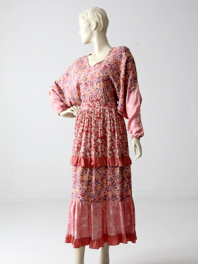 1970s Bohemian Pink Floral Dress with Tiered Skirt and Ribbon Belt: 1970s Bohemian Pink Floral Dress with Tiered Skirt and Ribbon Belt Step back into the vibrant 1970s with this ultra-chic bohemian pink floral dress. Crafted from slinky rayon, it showcases a stunning 