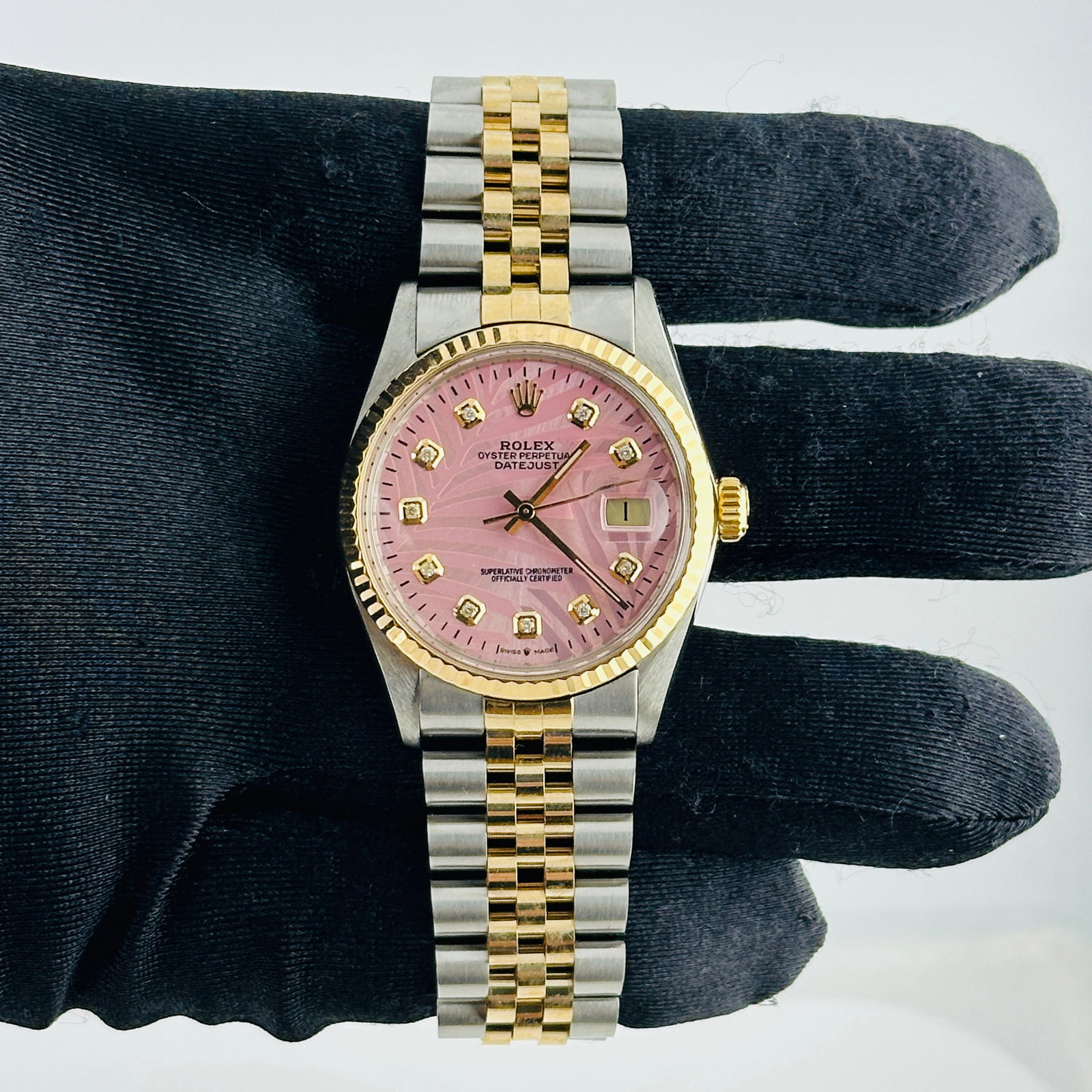 Rolex Datejust 16013 Pink Palm Dial Fluted Bezel Jubilee Bracelet: Rolex Datejust 16013 Pink Palm Dial Fluted Bezel Jubilee Bracelet This men's Rolex Datejust features an aftermarket pink palm motif dial with yellow gold diamond markers, complemented by a fluted beze