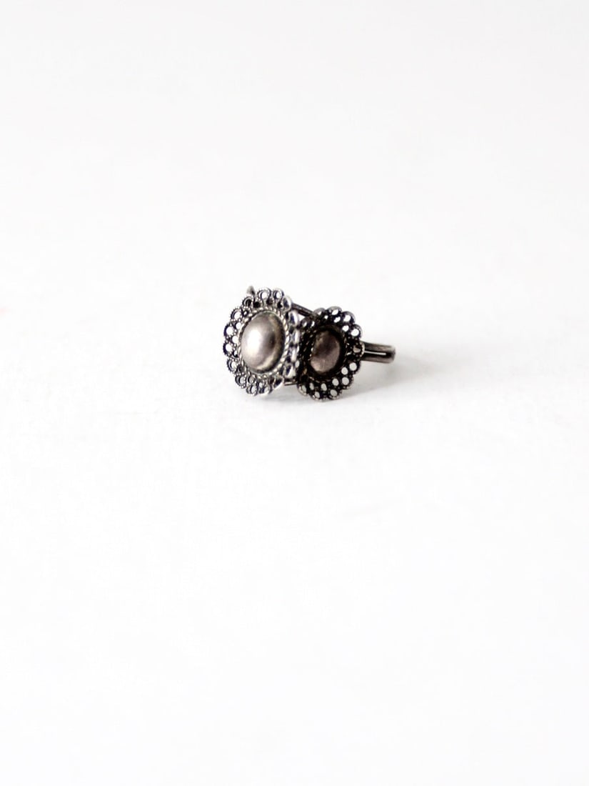 1970s Vintage Silver Tone Filigree Adjustable Statement Ring: 1970s Vintage Silver Tone Filigree Adjustable Statement Ring This stunning vintage ring from the 1970s showcases a striking silver tone finish and features three intricately designed filigree trimmed 