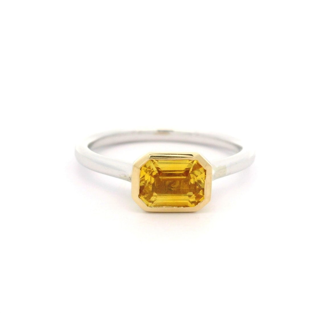 14K Gold 1.09ct Emerald Cut Yellow Sapphire Solitaire Ring: 14K Gold 1.09ct Emerald Cut Yellow Sapphire Solitaire Ring This stunning 14k White and Yellow Gold ring features a magnificent 1.09ct natural yellow sapphire in an emerald cut, elegantly bezel set. Th