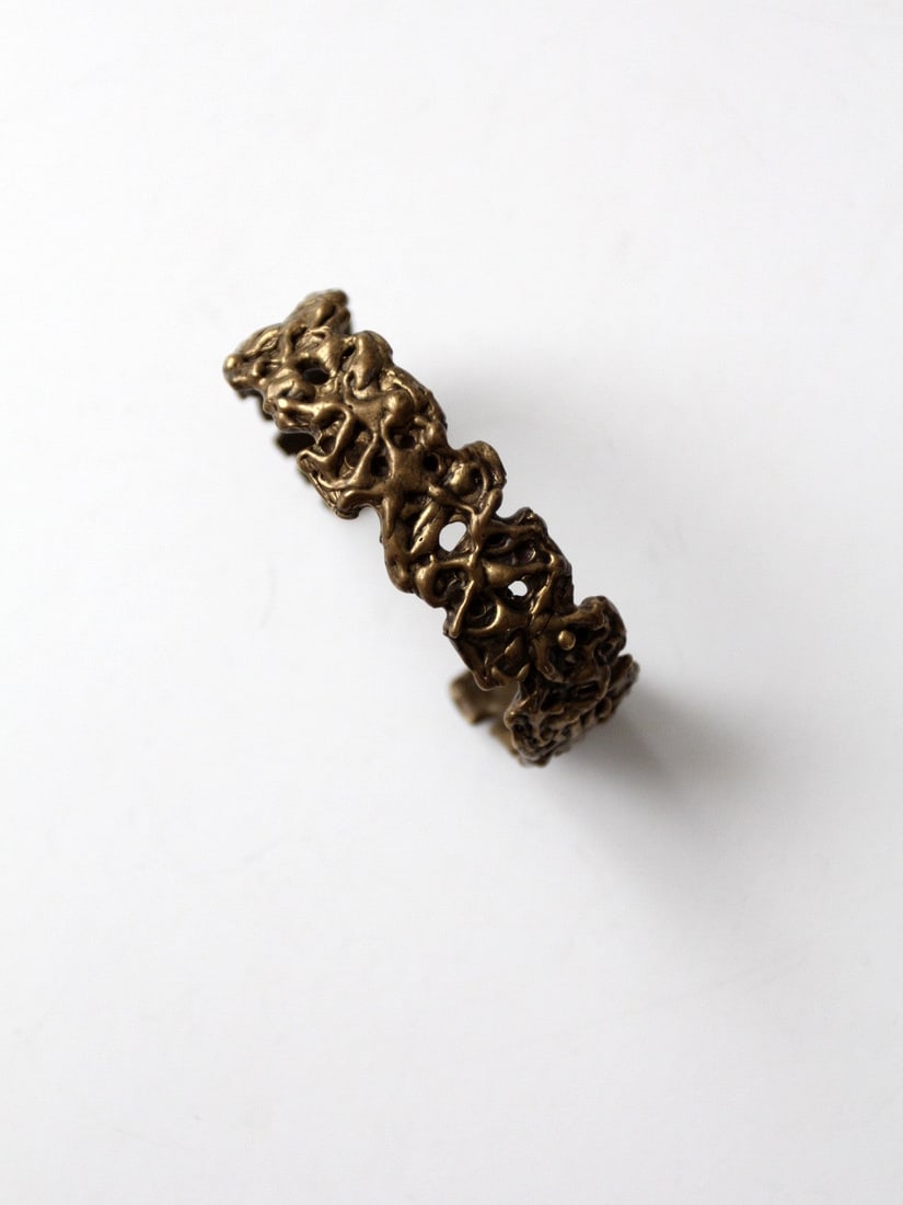1960s Vintage Brutalist Brass Cuff Hand-Crafted Intricate Design: 1960s Vintage Brutalist Brass Cuff Hand-Crafted Intricate Design This stunning 1960s vintage brutalist brass cuff is a hand-crafted piece that showcases intricate cast detailing and a striking patina.
