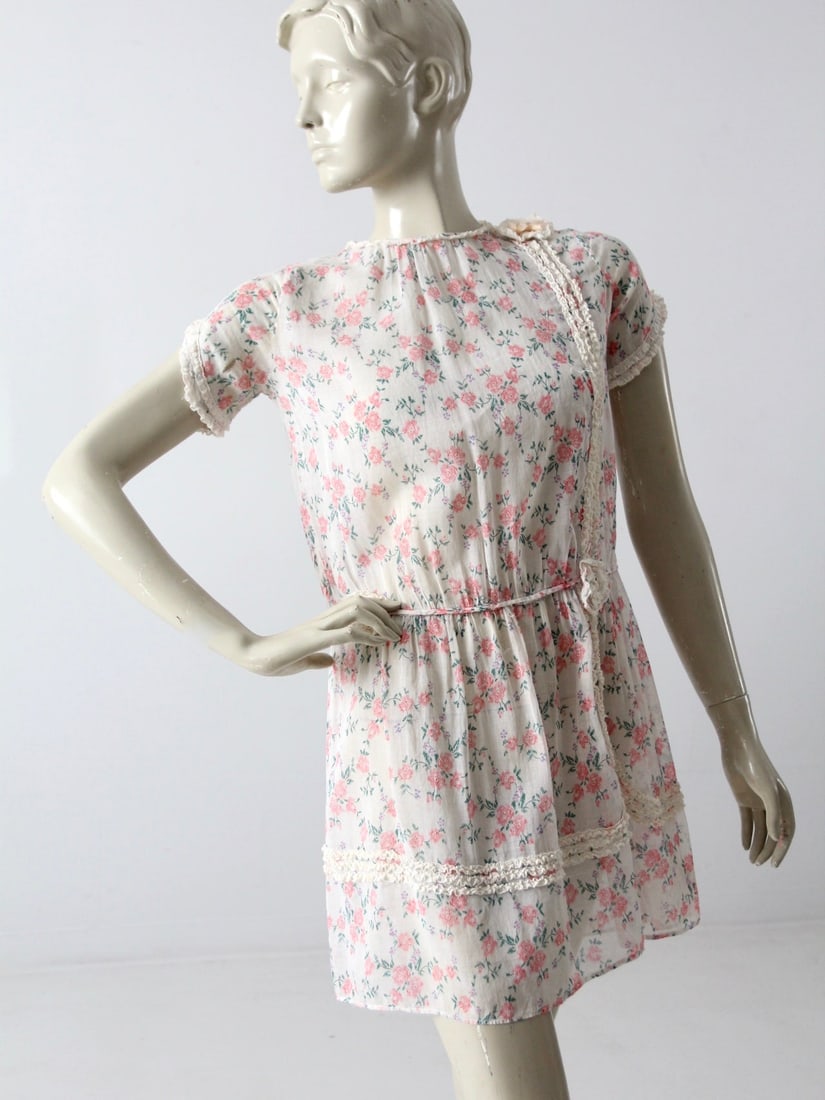 1920s Vintage Floral Cotton Dress with Ruffle Lace Trims: 1920s Vintage Floral Cotton Dress with Ruffle Lace Trims This vintage floral dress, dating back to the 1920s, showcases a delicate sheer white cotton fabric adorned with a charming pink floral print. 