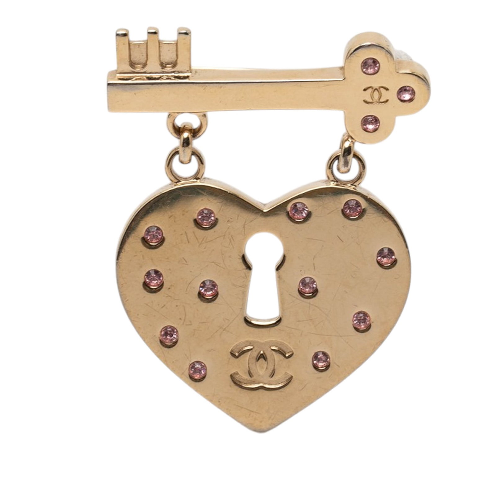Chanel CC Heart Lock Key Brooch Pin Gold Plated Metal: Chanel CC Heart Lock Key Brooch Pin Gold Plated Metal This Chanel brooch features a gold-plated metal design with rhinestone embellishments in a heart lock and key motif. It is crafted in Italy and se