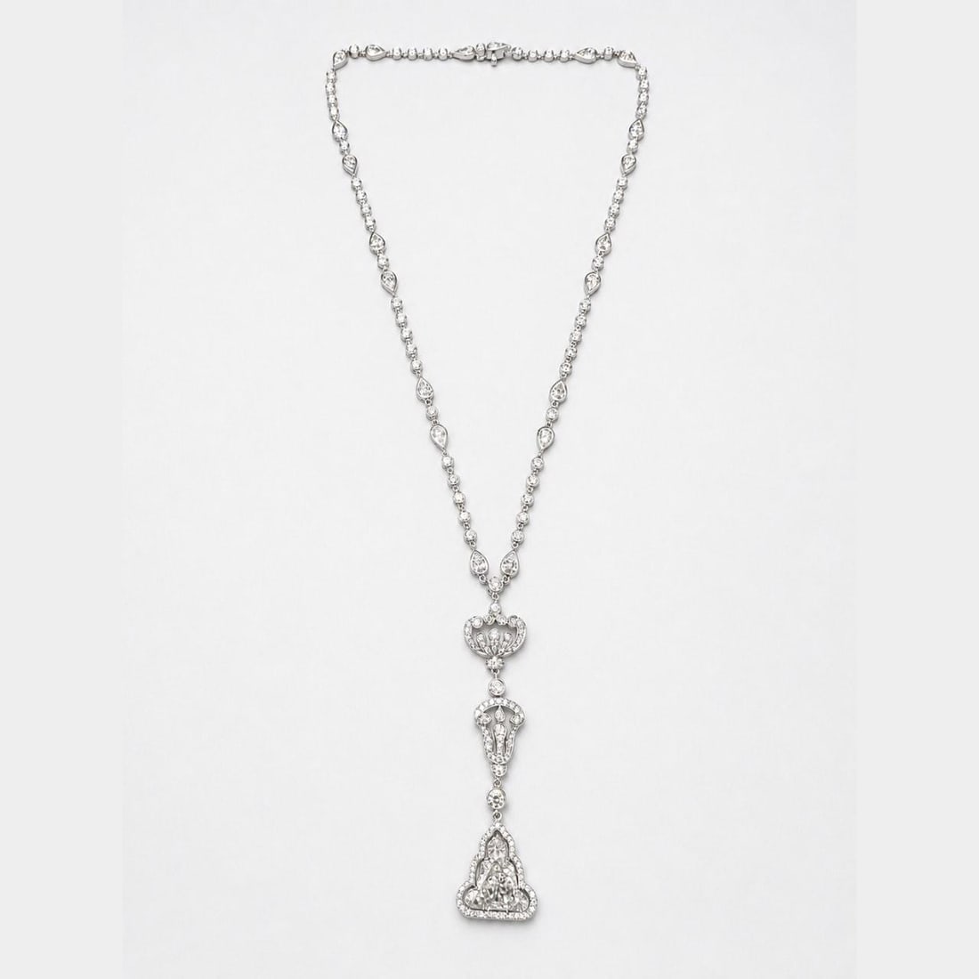 SCHREINER HRD Certified 18K White Gold Diamond Buddha Necklace: SCHREINER HRD Certified 18K White Gold Diamond Buddha Necklace An 18K white gold Buddha diamond necklace featuring an HRD certified 5.69 ct Buddha-cut diamond, accented by 20 pear-shape diamonds and 1