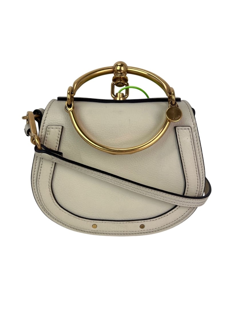 Chloe Nile Small Beige Leather Crossbody Bag with Gold Hardware: Chloe Nile Small Beige Leather Crossbody Bag with Gold Hardware Introducing the Chloe Nile Small Wrist Crossbody Bag, a sophisticated accessory crafted in Italy. This exquisite bag features a stylish 