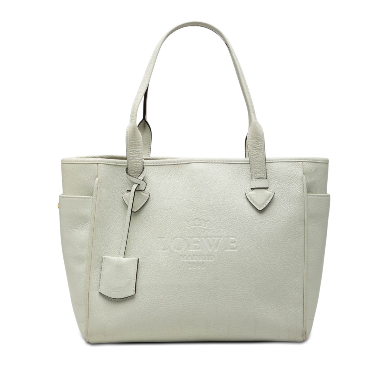 LOEWE Heritage Tote White Leather Handbag: LOEWE Heritage Tote White Leather Handbag LOEWE Leather Heritage Tote in white leather, made in Spain. It features flat leather handles, an open top with hook lock closure, exterior side slip pockets,