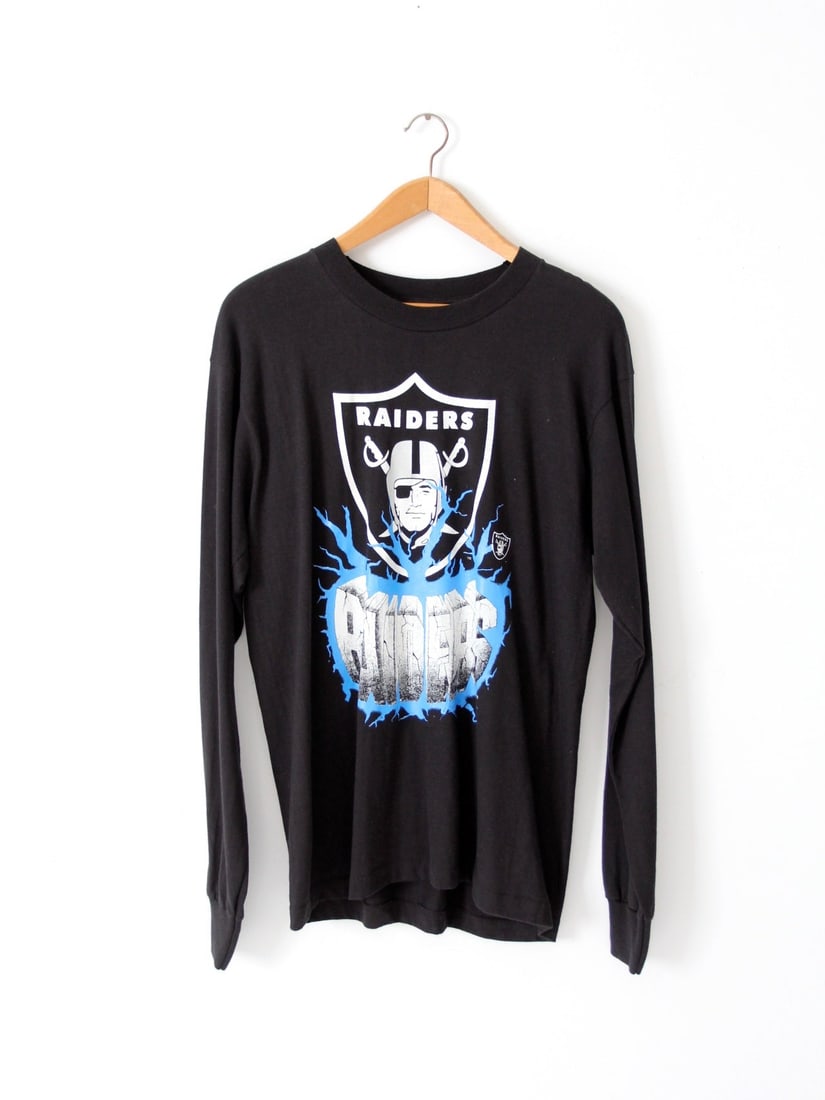 Vintage 1980s Raiders Long Sleeve T-Shirt Los Angeles Edition: Vintage 1980s Raiders Long Sleeve T-Shirt Los Angeles Edition Celebrate your love for the Raiders with this vintage 1980s football t-shirt from their Los Angeles years (1982-1994). This stylish long s