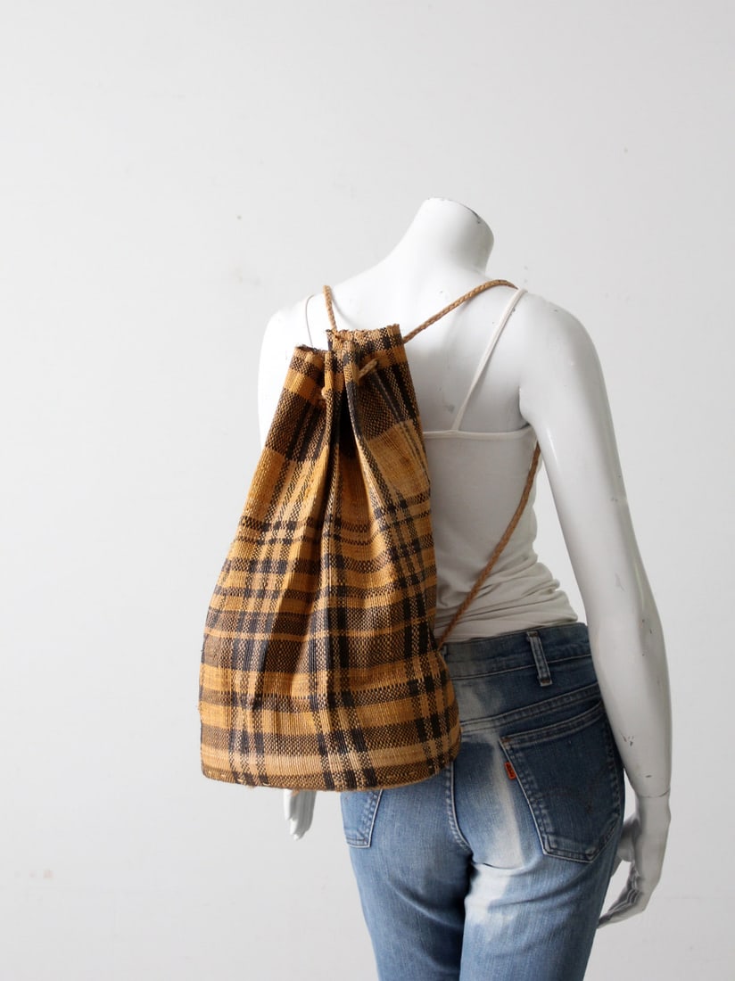 Vintage Woven Drawstring Backpack Goldenrod Black Plaid 10 inch Base: Vintage Woven Drawstring Backpack Goldenrod Black Plaid 10 inch Base This vintage woven drawstring backpack showcases a striking goldenrod and black plaid pattern. Crafted from durable woven fibers, i