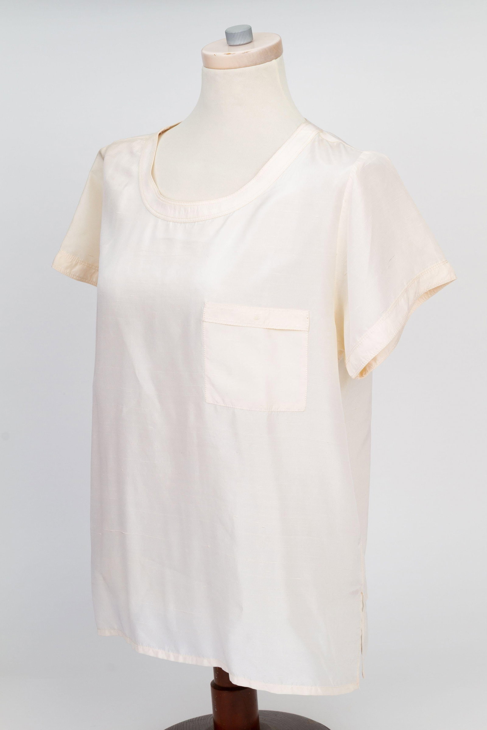 Chanel Silk Short Sleeve Cream Shirt French Size 42: Chanel Silk Short Sleeve Cream Shirt French Size 42 This Chanel cream short sleeve blouse is crafted from 100% silk and features a loose fit for comfort and style. Designed in a French size 42 (US lar