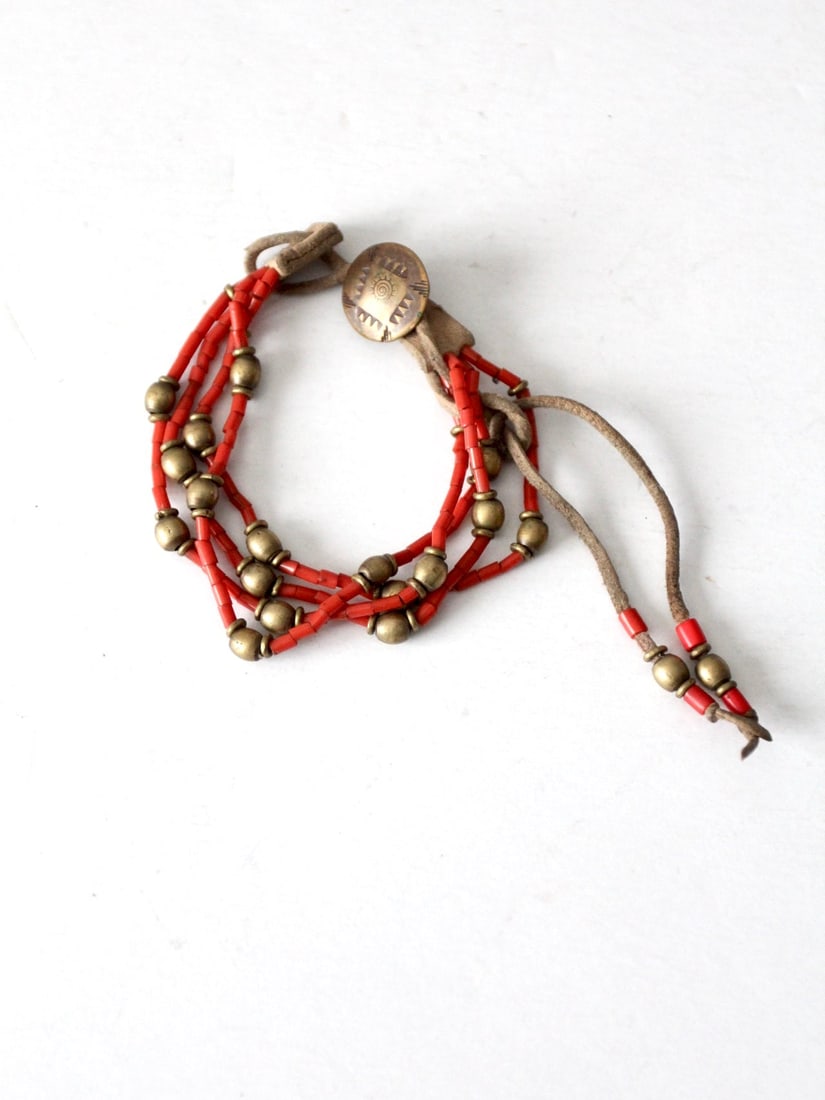 Vintage Boho Adjustable Beaded Bracelet with Copper Medallion: Vintage Boho Adjustable Beaded Bracelet with Copper Medallion Embrace a boho vintage aesthetic with this exquisite beaded bracelet. Crafted from slender leather strands, this bracelet features a capti